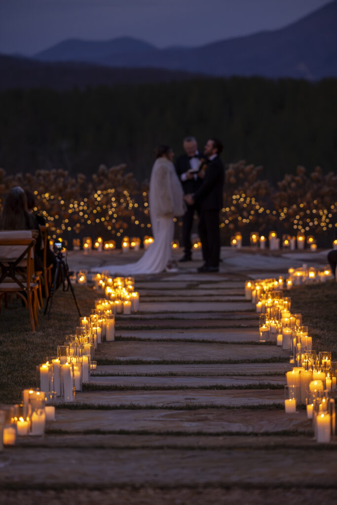 A couple getting married in the evening at their mountain wedding.