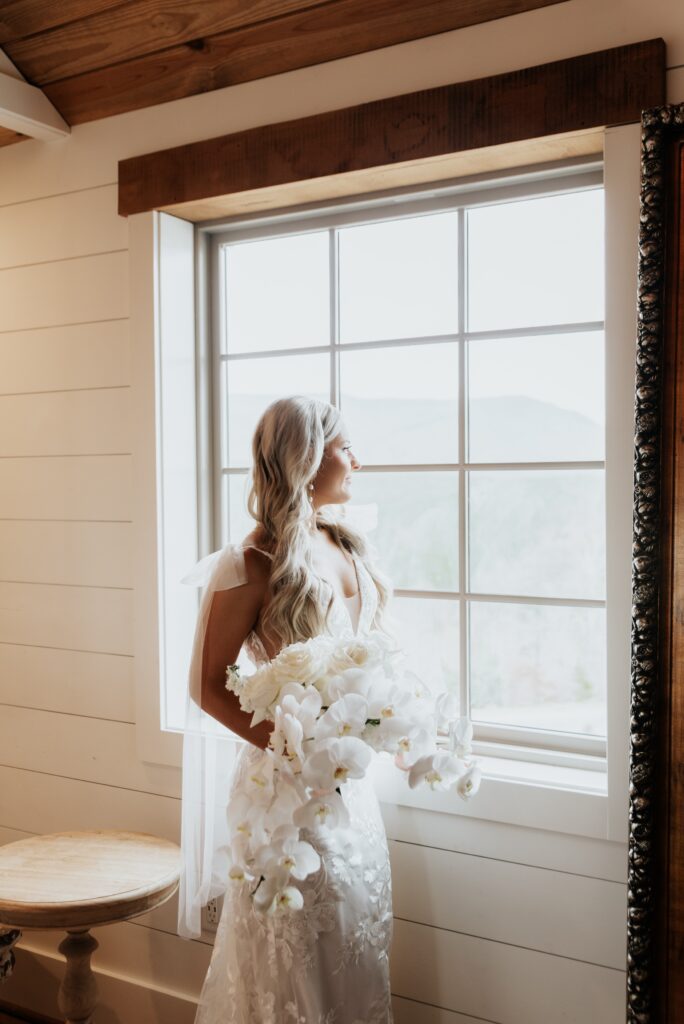 Bride looking out the window of a luxurious Virginia wedding venue.