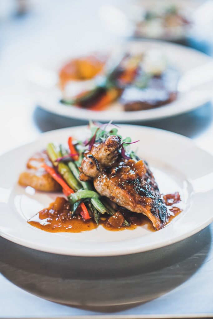 Grilled chicken entrée with seasonal vegetables and savory sauce served at a Blue Ridge mountain wedding reception